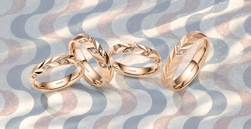 Anillos de boda exclusivos Acredo de la colección Morning Glow, sobre un fondo del emblemático Paseo de la Explanada en Alicante. Anillos de boda únicos y personalizables con el asesoramiento experto de Joyería Marga Mira